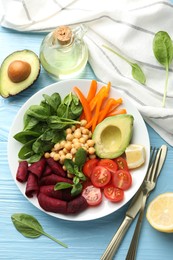 Photo of Different healthy vegetarian food and cutlery on light blue wooden table, flat lay