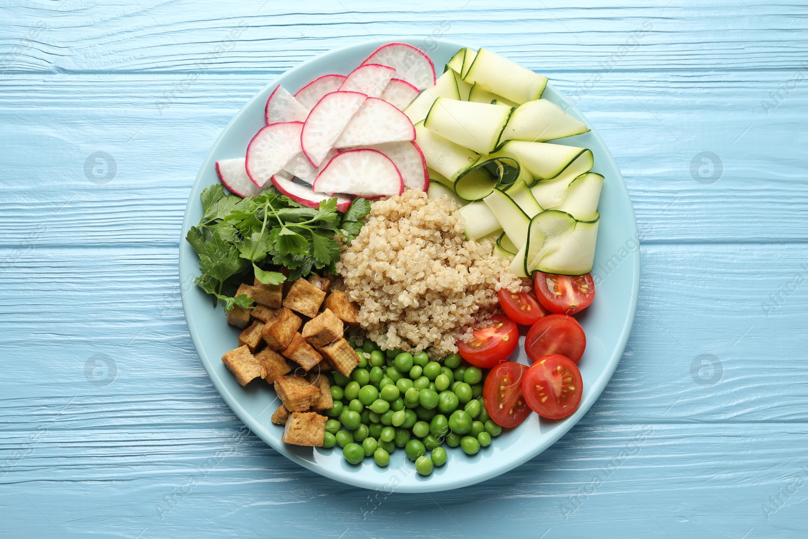 Photo of Different healthy vegetarian food on light blue wooden table, top view