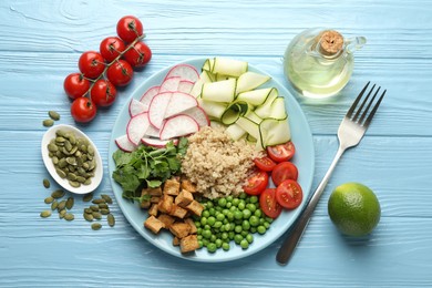 Photo of Different healthy vegetarian food served on light blue wooden table, flat lay