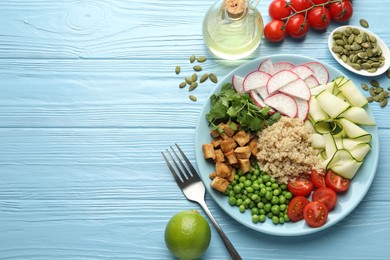 Photo of Different healthy vegetarian food served on light blue wooden table, flat lay. Space for text