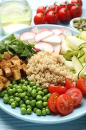 Photo of Different healthy vegetarian food on light blue wooden table, closeup