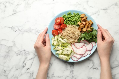 Photo of Woman with different healthy vegetarian food at white marble table, top view. Space for text
