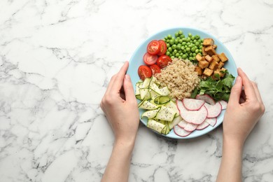 Photo of Woman with different healthy vegetarian food at white marble table, top view. Space for text