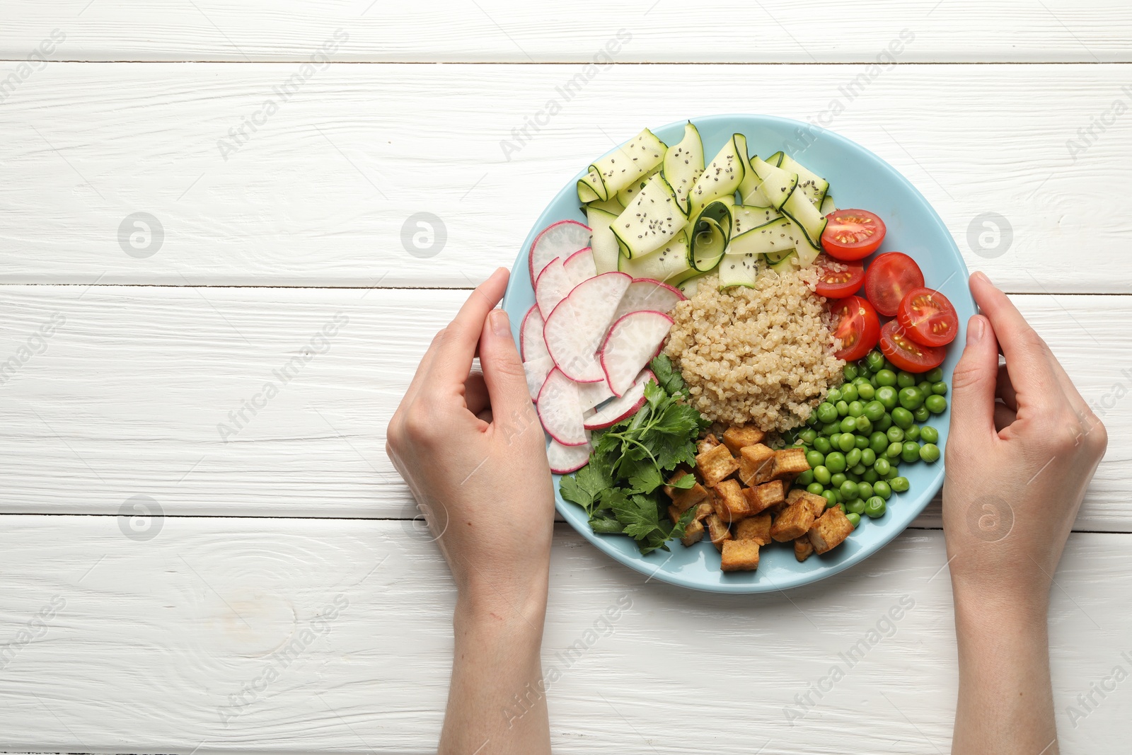 Woman with different healthy vegetarian food at white wooden table, top view. Space for text Photo of Woman with different healthy vegetarian food at white wooden table, top view. Space for text