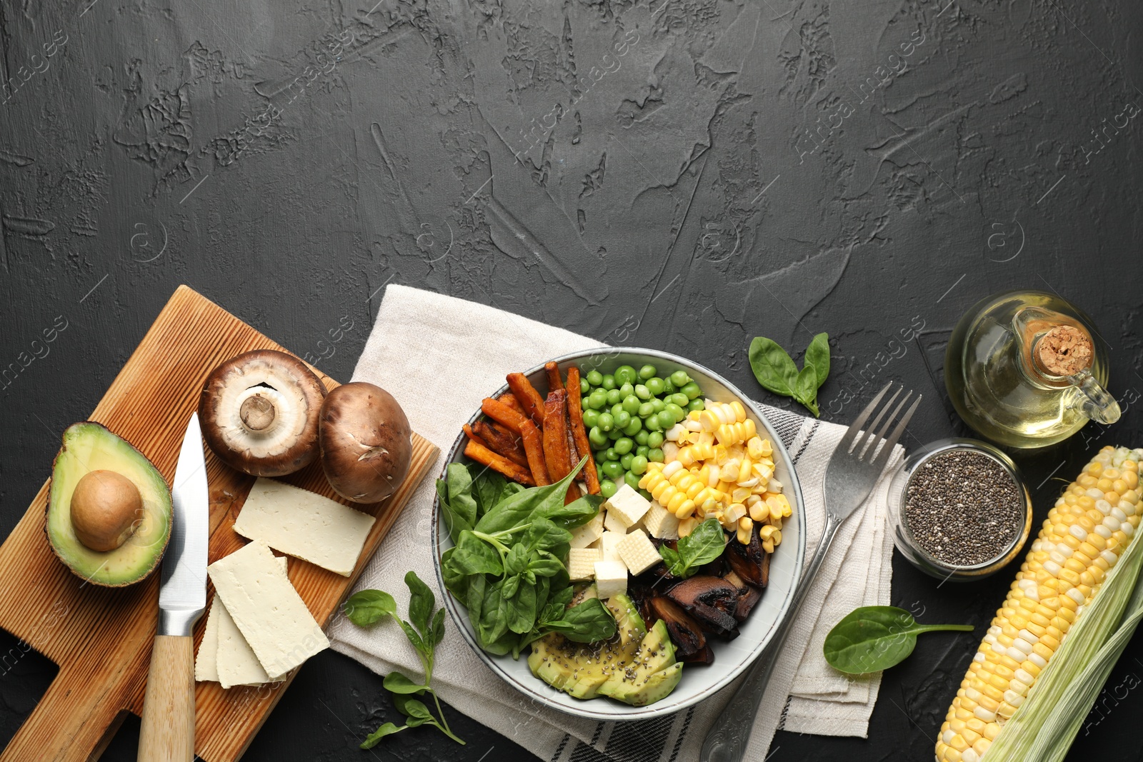 Healthy vegetarian food. Delicious Buddha bowl and ingredients on black table, flat lay. Space for text Photo of Healthy vegetarian food. Delicious Buddha bowl and ingredients on black table, flat lay. Space for text