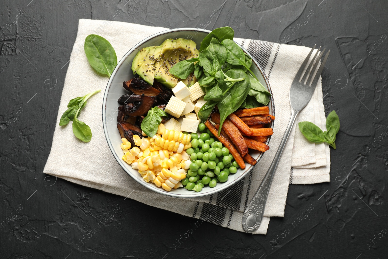 Healthy vegetarian food. Delicious Buddha bowl on black table, flat lay Photo of Healthy vegetarian food. Delicious Buddha bowl on black table, flat lay