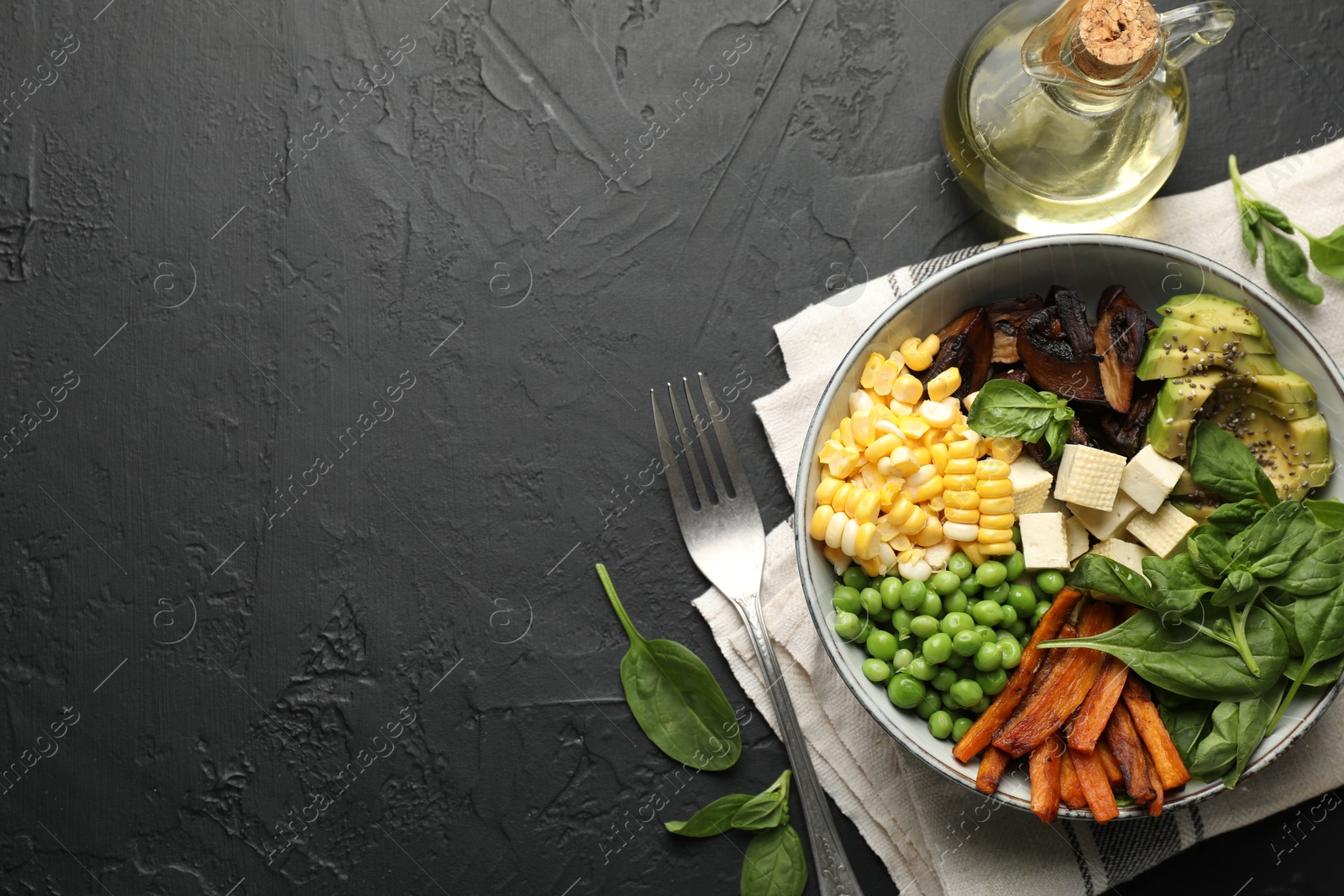 Healthy vegetarian food. Delicious Buddha bowl on black table, flat lay. Space for text Photo of Healthy vegetarian food. Delicious Buddha bowl on black table, flat lay. Space for text