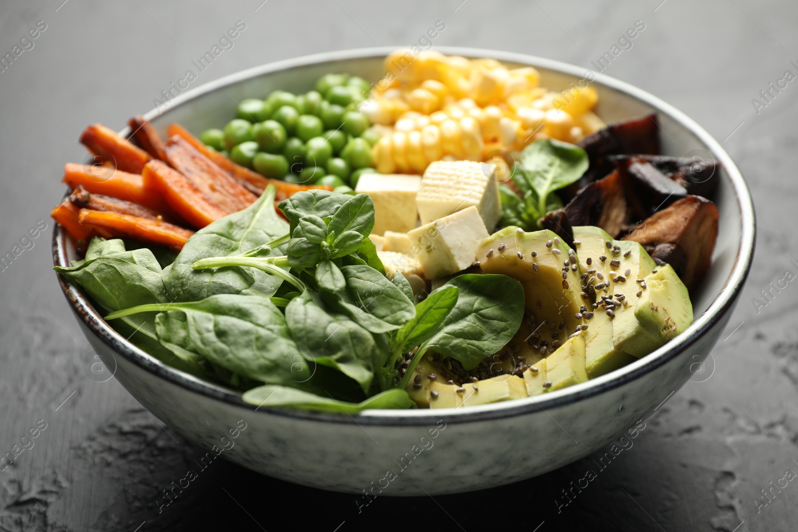Healthy vegetarian food. Delicious Buddha bowl on black table, closeup Photo of Healthy vegetarian food. Delicious Buddha bowl on black table, closeup