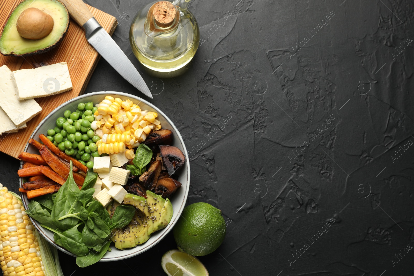 Healthy vegetarian food. Delicious Buddha bowl and ingredients on black table, flat lay. Space for text Photo of Healthy vegetarian food. Delicious Buddha bowl and ingredients on black table, flat lay. Space for text