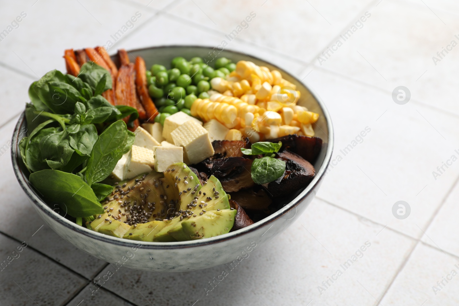 Healthy vegetarian food. Delicious Buddha bowl on light tiled table, closeup. Space for text Photo of Healthy vegetarian food. Delicious Buddha bowl on light tiled table, closeup. Space for text
