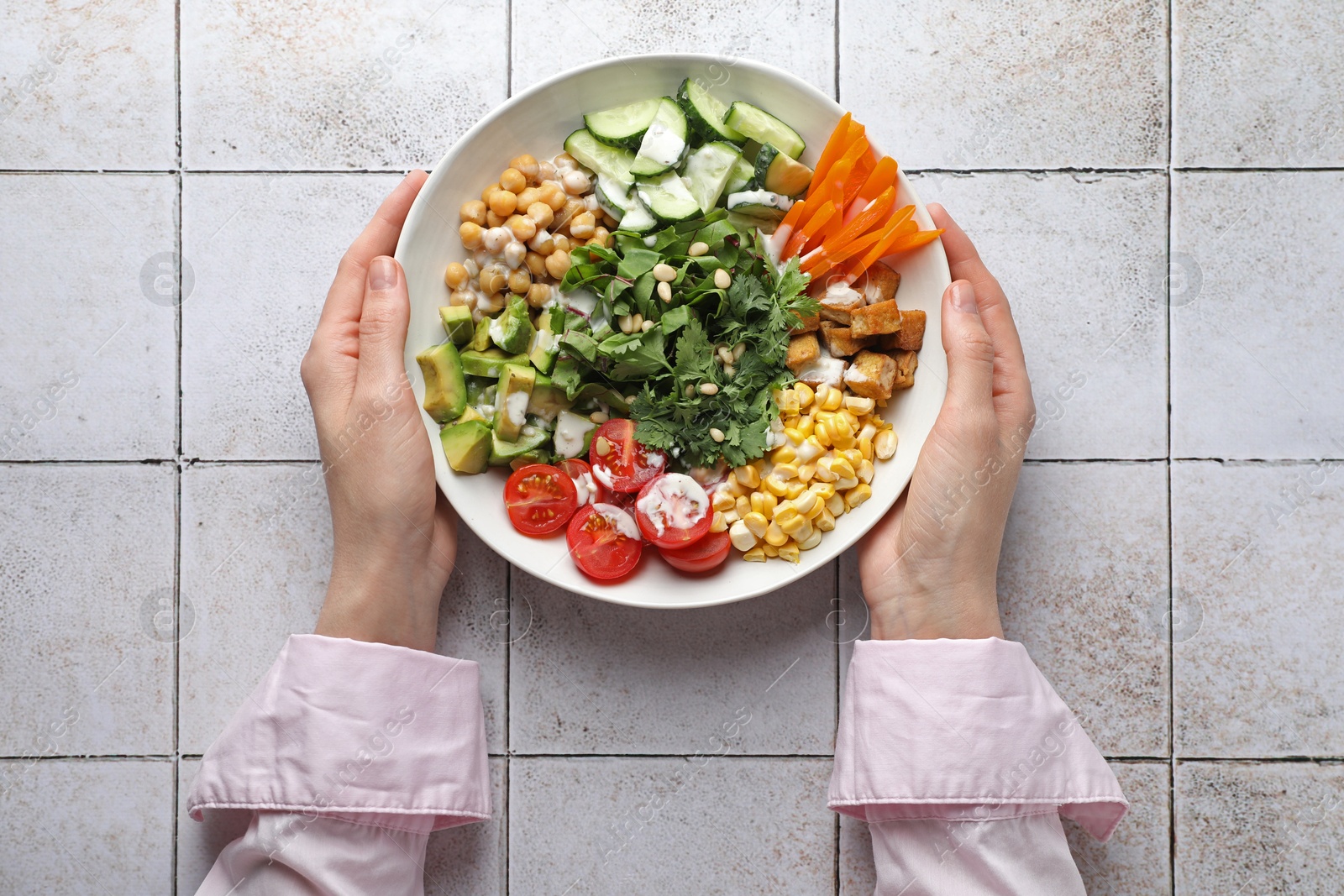Woman with different healthy vegetarian food at light tiled table, top view Photo of Woman with different healthy vegetarian food at light tiled table, top view