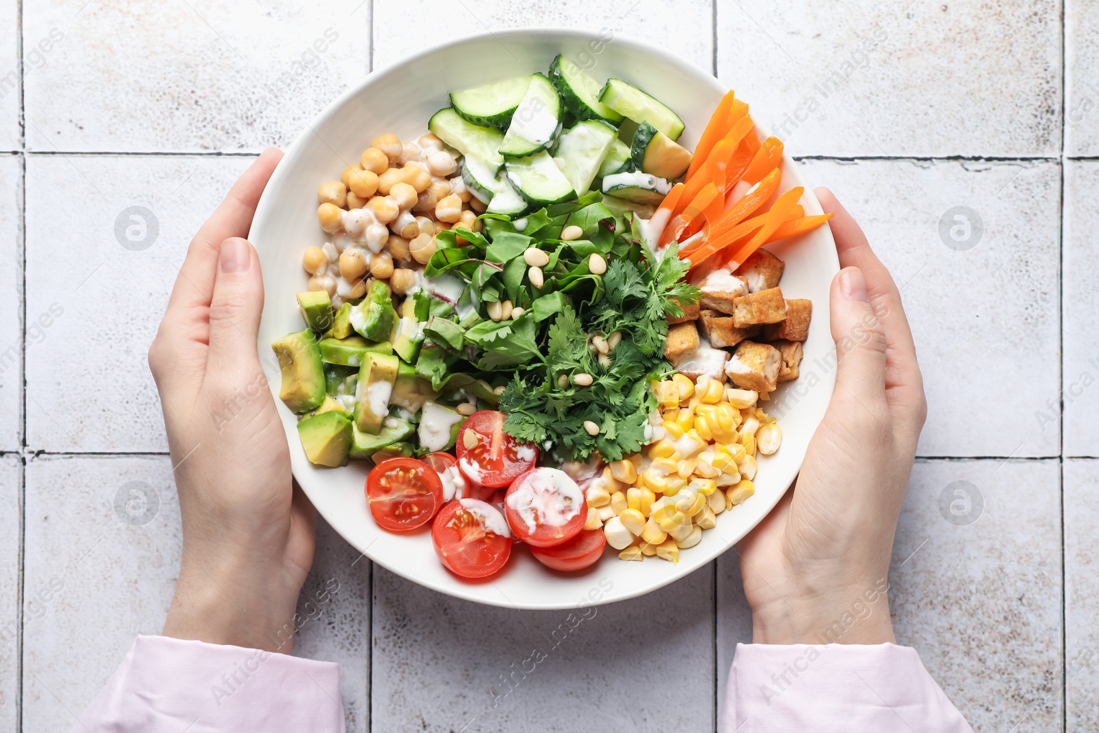 Woman with different healthy vegetarian food at light tiled table, top view Photo of Woman with different healthy vegetarian food at light tiled table, top view