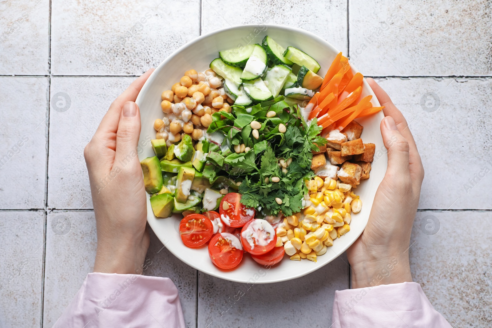 Woman with different healthy vegetarian food at light tiled table, top view Photo of Woman with different healthy vegetarian food at light tiled table, top view