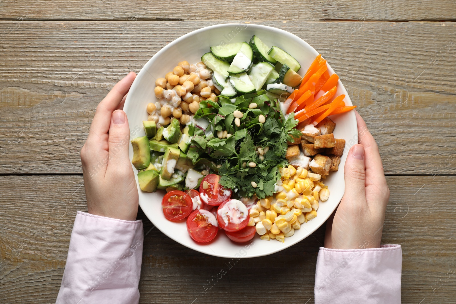 Woman with different healthy vegetarian food at wooden table, top view Photo of Woman with different healthy vegetarian food at wooden table, top view