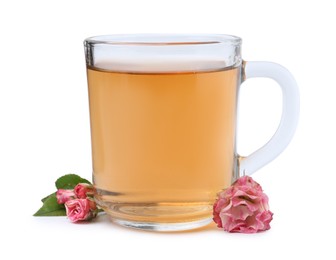 Photo of Aromatic tea in glass cup, roses and green leaves isolated on white
