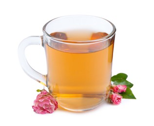 Photo of Aromatic tea in glass cup, roses and green leaves isolated on white