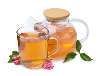 Photo of Aromatic tea in glass cup, teapot, roses and green leaves isolated on white