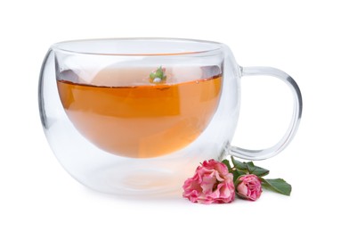 Photo of Aromatic tea in glass cup, roses and green leaves isolated on white