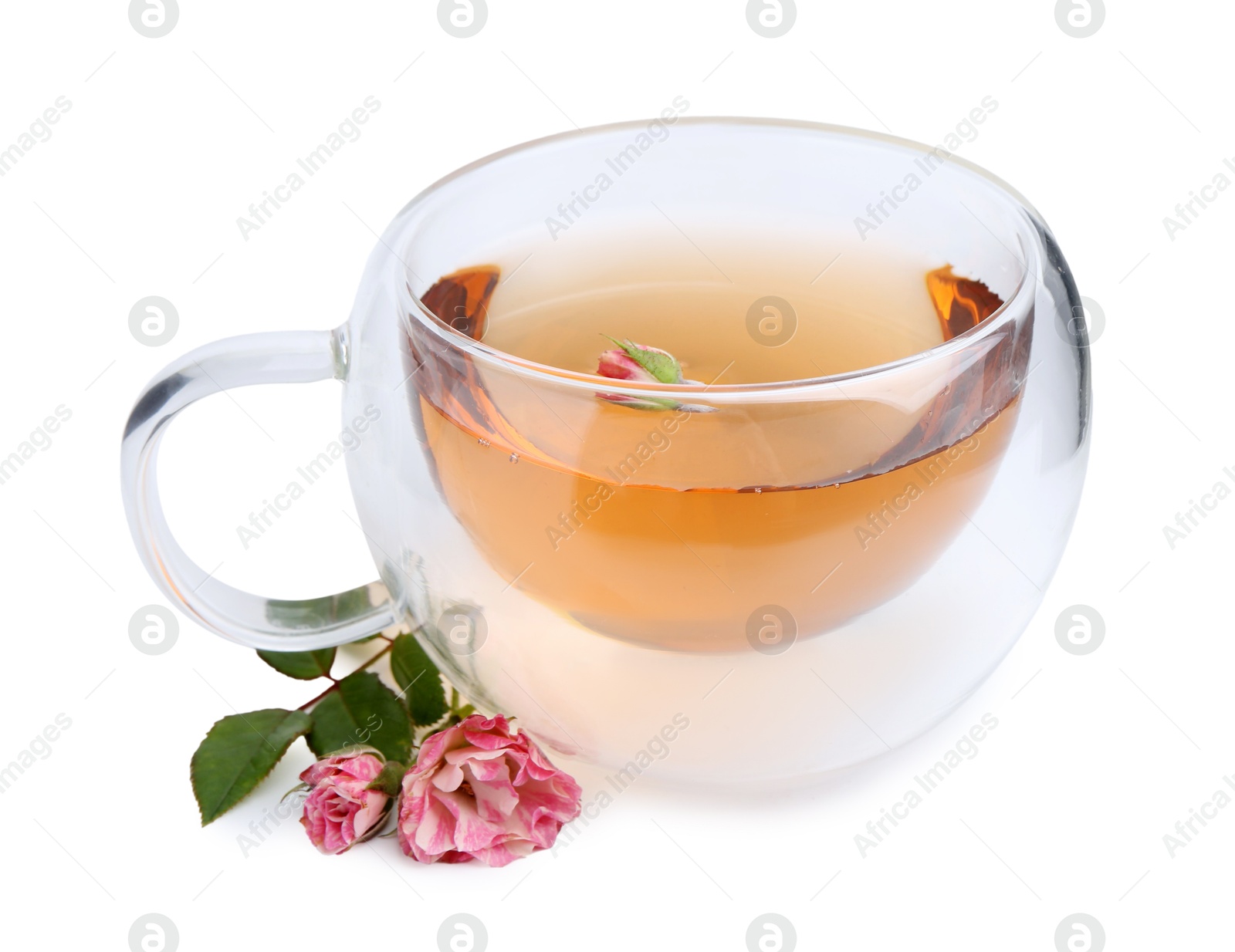 Aromatic tea in glass cup, roses and green leaves isolated on white Photo of Aromatic tea in glass cup, roses and green leaves isolated on white