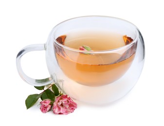 Photo of Aromatic tea in glass cup, roses and green leaves isolated on white
