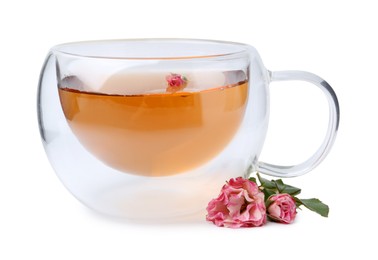 Photo of Aromatic tea in glass cup, roses and green leaves isolated on white