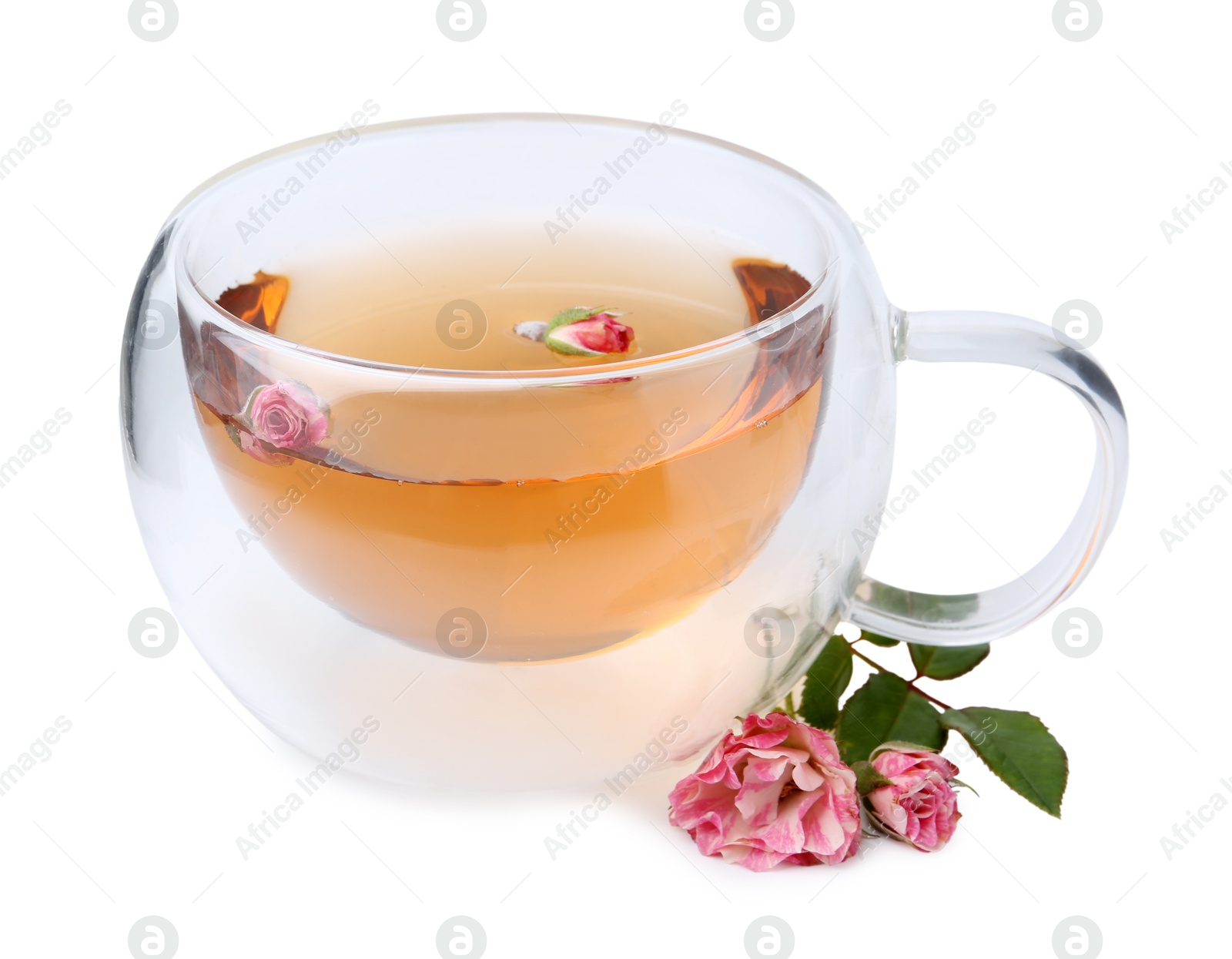 Aromatic tea in glass cup, roses and green leaves isolated on white Photo of Aromatic tea in glass cup, roses and green leaves isolated on white