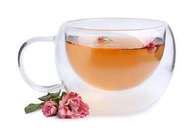 Photo of Aromatic tea in glass cup, roses and green leaves isolated on white