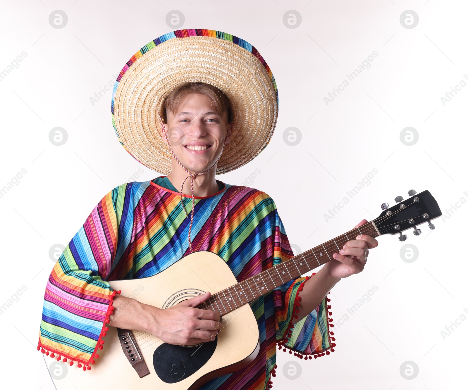 Smiling man in sombrero hat and colorful poncho playing guitar on white background Photo of Smiling man in sombrero hat and colorful poncho playing guitar on white background