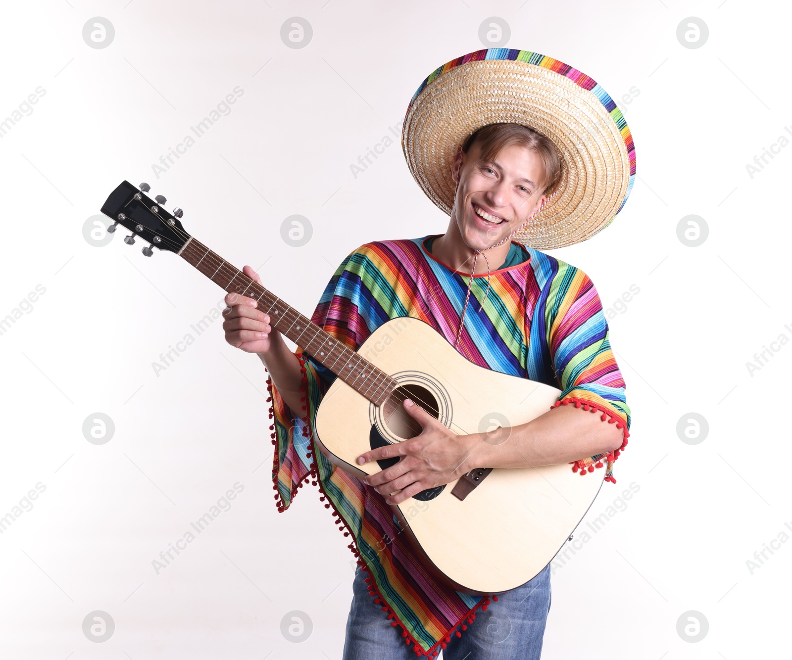 Smiling man in sombrero hat and colorful poncho playing guitar on white background Photo of Smiling man in sombrero hat and colorful poncho playing guitar on white background