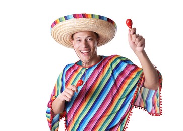 Photo of Smiling man in sombrero hat and colorful poncho playing maracas on white background