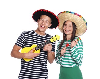 Photo of Happy couple in sombrero and Flamenco hats playing musical instruments on white background