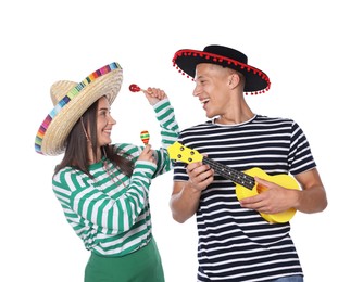 Photo of Happy couple in sombrero and Flamenco hats playing musical instruments on white background