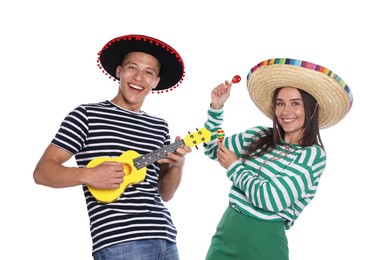 Photo of Happy couple in sombrero and Flamenco hats playing musical instruments on white background