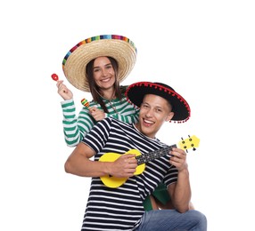 Photo of Happy couple in sombrero and Flamenco hats playing musical instruments on white background