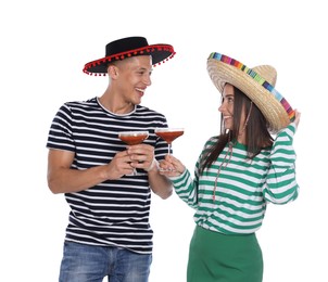 Photo of Happy couple in sombrero and Flamenco hats with cocktails on white background