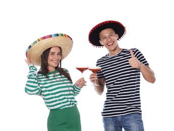 Photo of Happy couple in sombrero and Flamenco hats with cocktails on white background