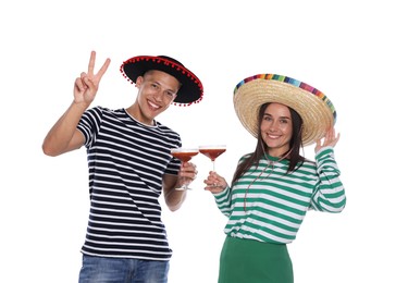 Photo of Happy couple in sombrero and Flamenco hats with cocktails on white background