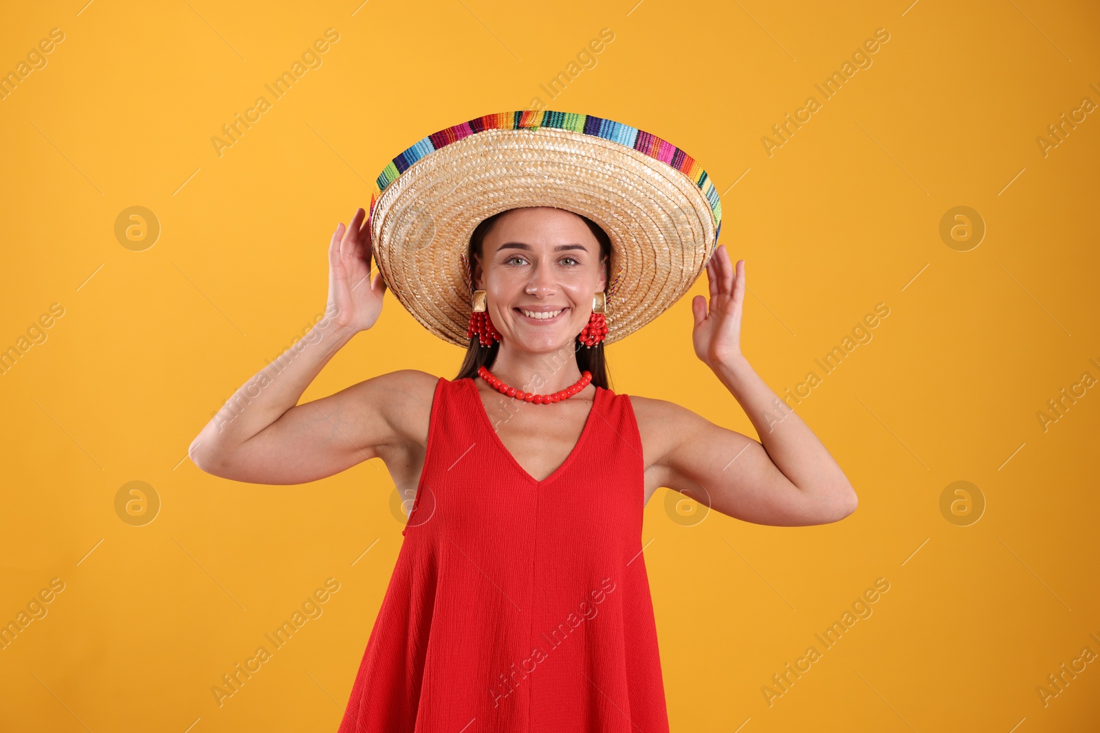 Happy woman in sombrero hat on yellow background Photo of Happy woman in sombrero hat on yellow background