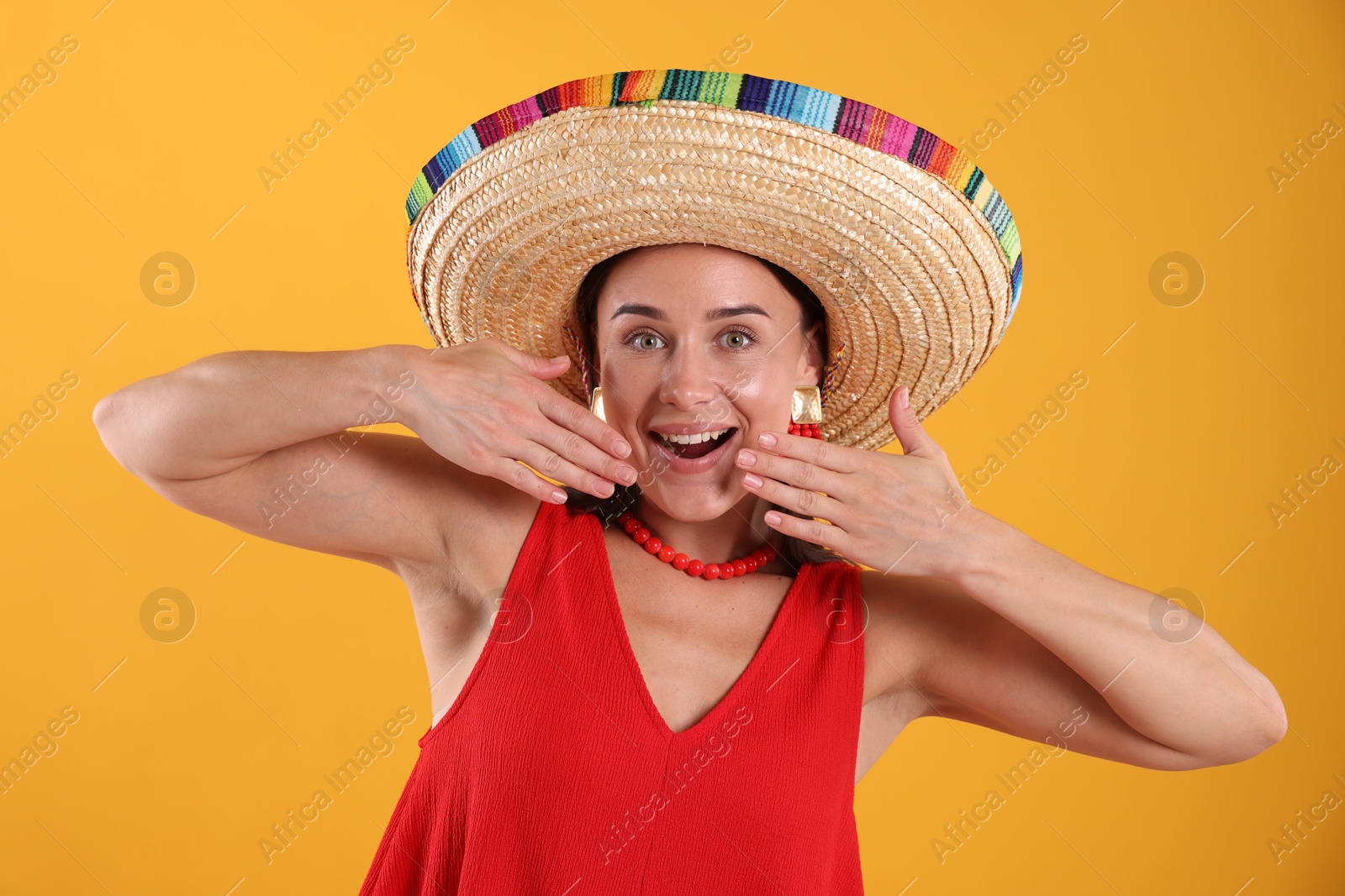 Happy woman in sombrero hat on yellow background Photo of Happy woman in sombrero hat on yellow background