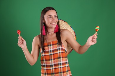 Photo of Smiling woman with sombrero hat playing maracas on green background