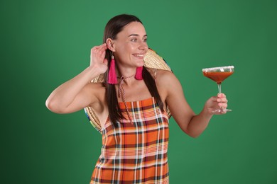 Photo of Smiling woman with sombrero hat and cocktail on green background