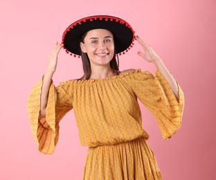 Photo of Smiling woman in black Flamenco hat and dress on pink background