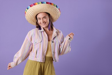 Photo of Smiling woman in sombrero hat on violet background. Space for text