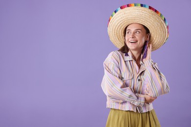 Photo of Smiling woman in sombrero hat on violet background. Space for text
