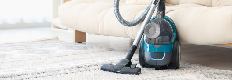 Photo of One vacuum cleaner on floor indoors. Household appliance