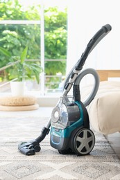 Photo of One vacuum cleaner on floor indoors. Household appliance