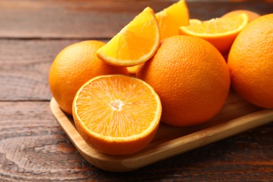 Photo of Fresh ripe oranges on wooden table, closeup