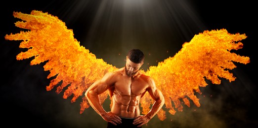 Image of Bodybuilder with flaming wings behind his back against dark background. Shirtless muscular man