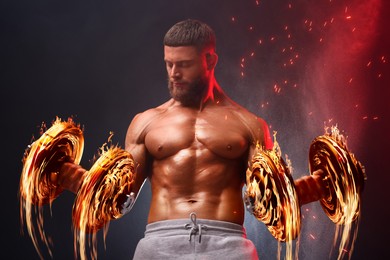 Image of Bodybuilder exercising with flaming dumbbells in smoke against dark background