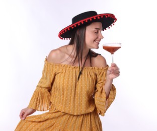 Photo of Smiling woman in black Flamenco hat and dress with cocktail on white background
